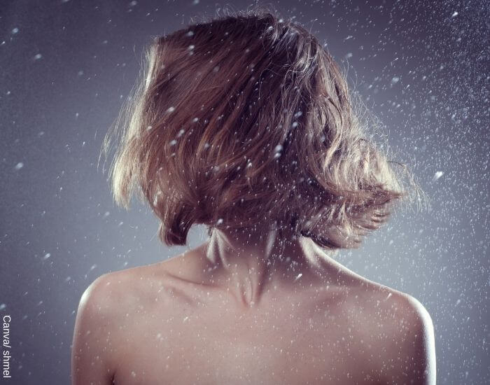 Foto de una mujer moviendo su pelo bajo la lluvia