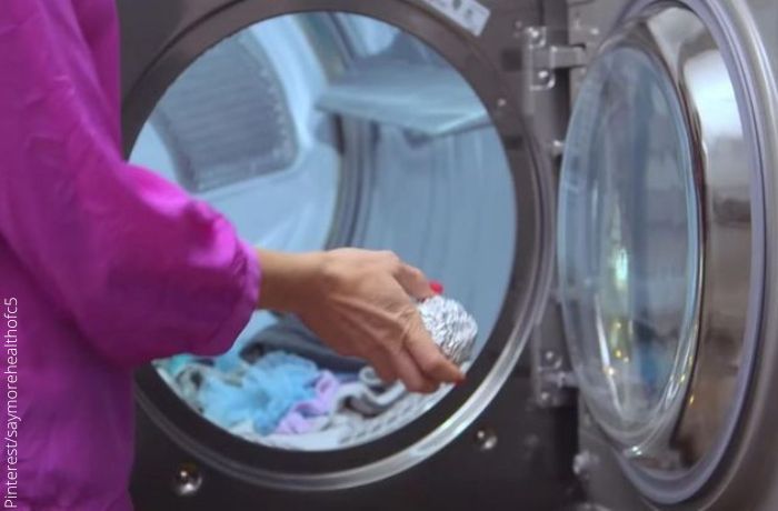 Foto de una mujer echándo una bola de aluminio a la lavadora