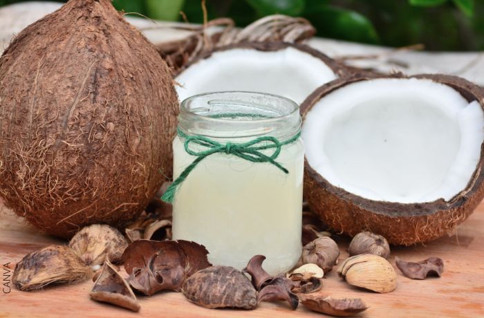 Foto de un frasco con de aceite de coco y cocos a los lados