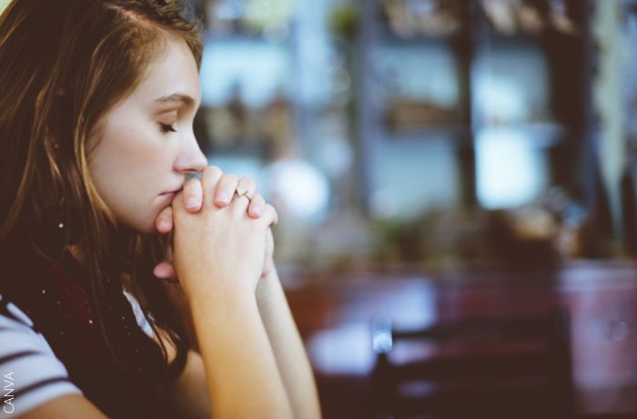 Foto de una mujer orando con los ojos cerrados
