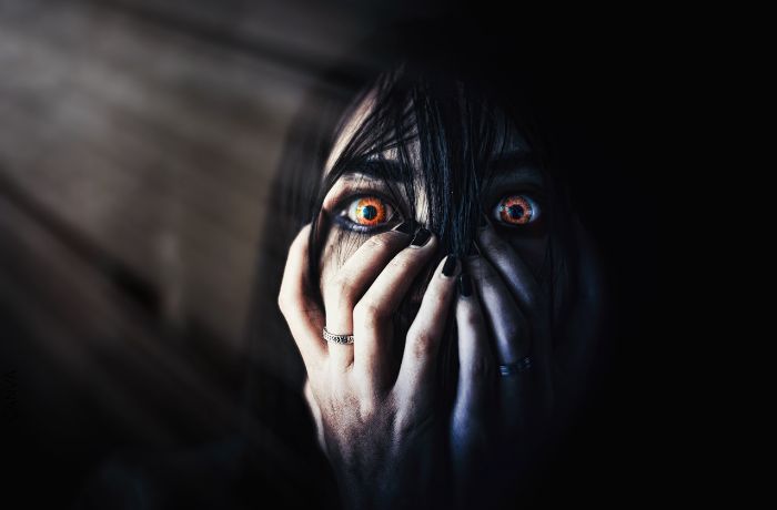 Foto de una mujer con los ojos colo naranja y expresión de miedo
