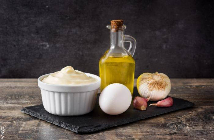 Foto de una salsa blanca, aceite, ajo y un huevo
