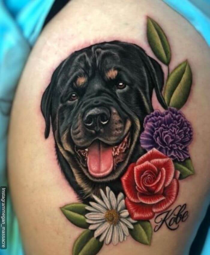 Foto del tatuaje de un rottweiler femenino acompañado de flores y hojas