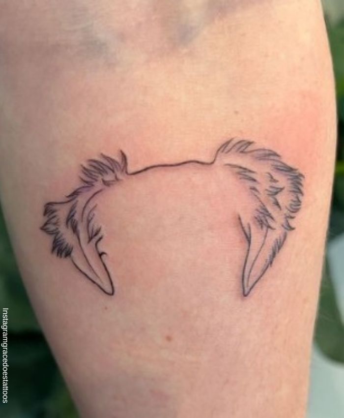 Foto de un tatuaje de orejas de perro en el antebrazo