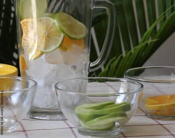 Foto de una jarra con hielo y rodajas de limón y naranja