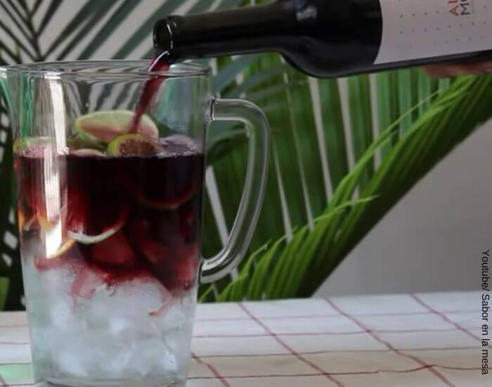 Foto de una jarra con hielo, soda de limón y vino tinto para preparar tinto de verano, receta refrescante