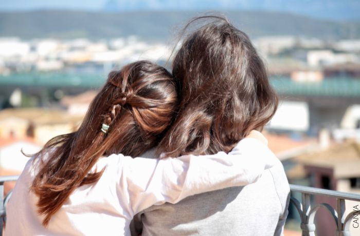 Foto de espaldas de dos mujeres abrazadas