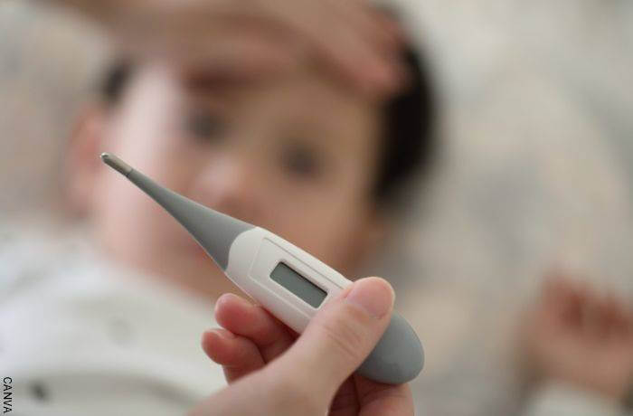 Foto de un bebé en segundo plano y al frente un termómetro