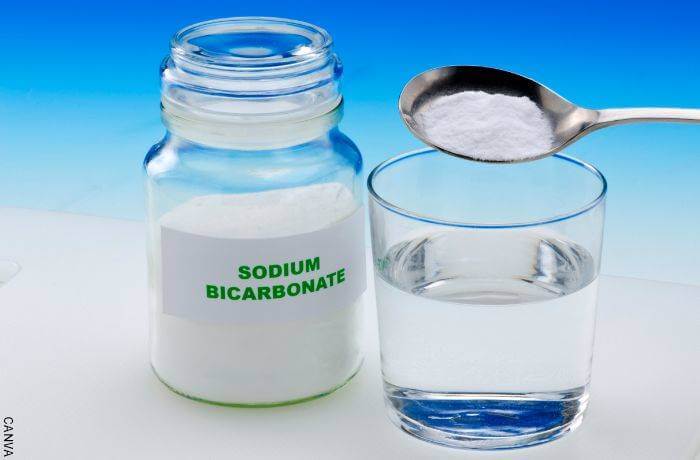 Foto de un frasco de bicarbonato de sodio y un vaso de agua