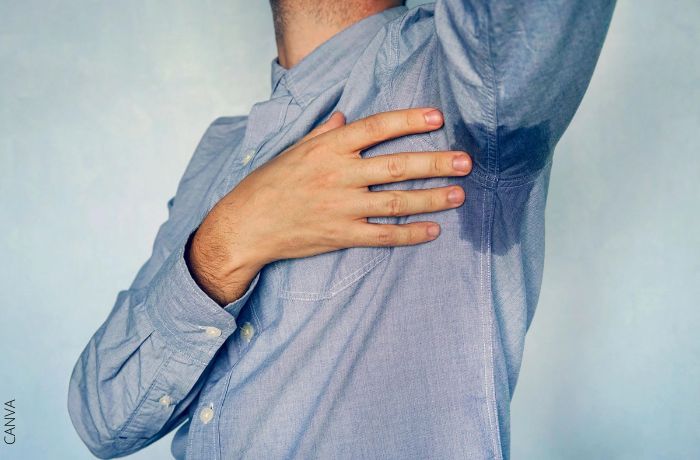 Foto de una persona con una mancha de sudor en la camisa en la zona de la axila
