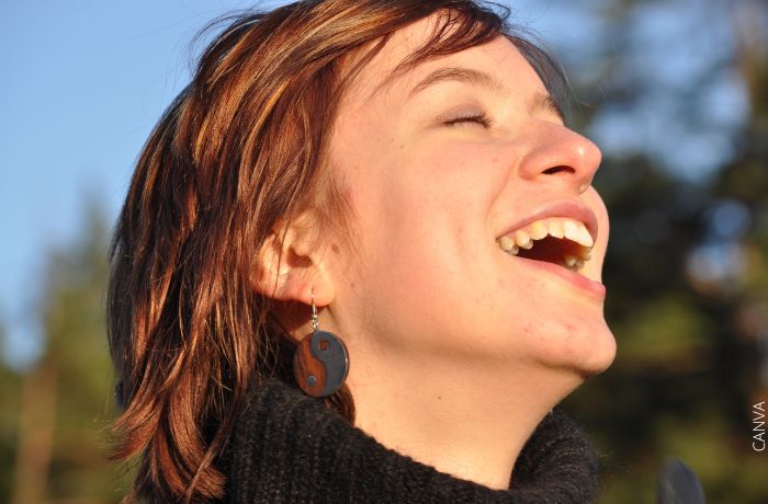 Foto de una mujer riendo con los ojos cerrados