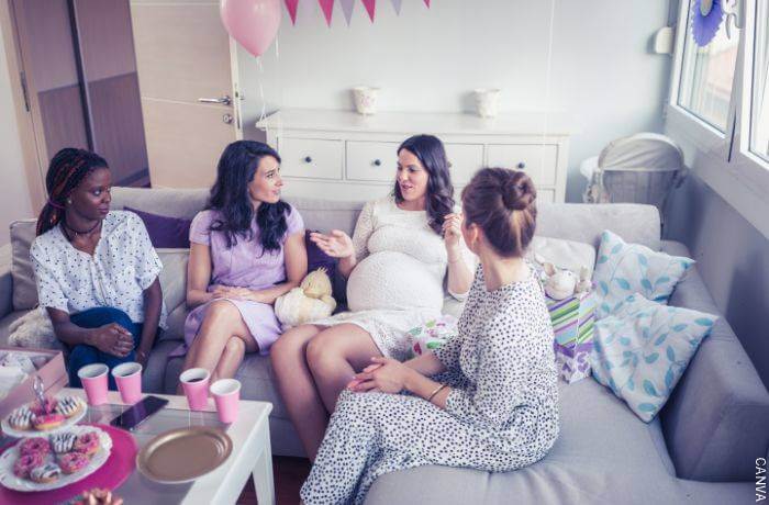 Foto de una mujer embarazada con sus amigas