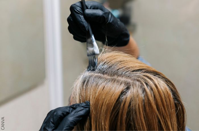 Foto de una persona aplicando un producto en el cabello con una brocha