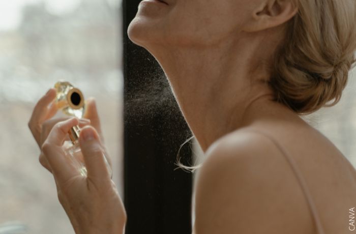 Foto de una mujer aplicándose perfume