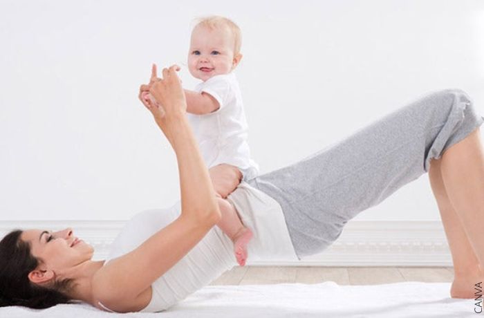 Foto de una mujer haciendo ejercicio con su bebé encima