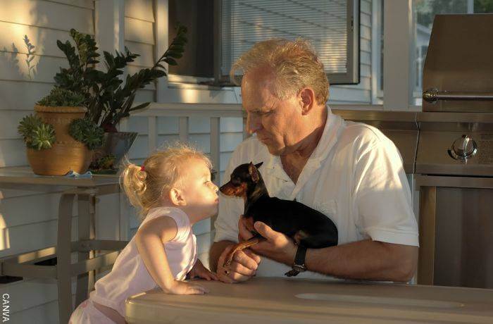 Foto de un abuelo con su nieta y un perrito