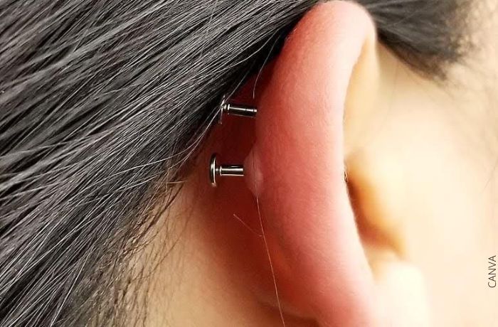 Foto de una oreja con una bolita en el piercing
