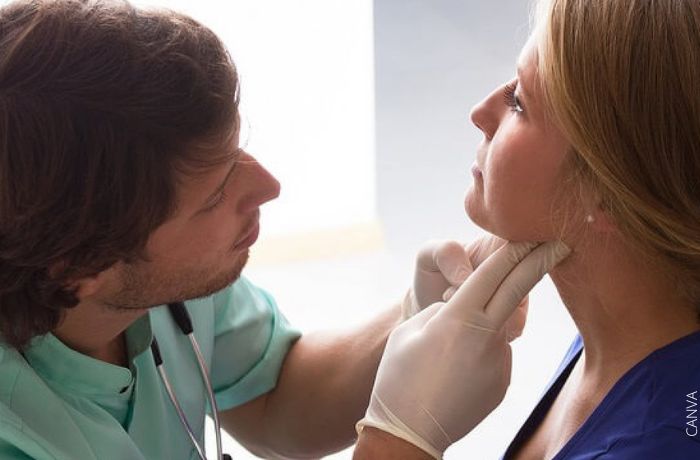 Foto de un doctor mirando el cuello de una mujer