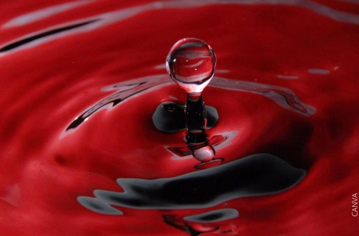 Foto de agua roja con una gota salpicando hacia arriba