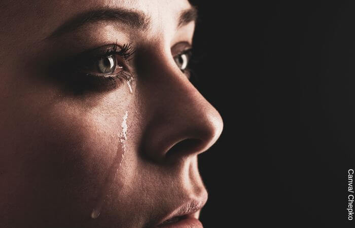 Foto de perfil de una mujer llorando para representar los beneficios de llorar