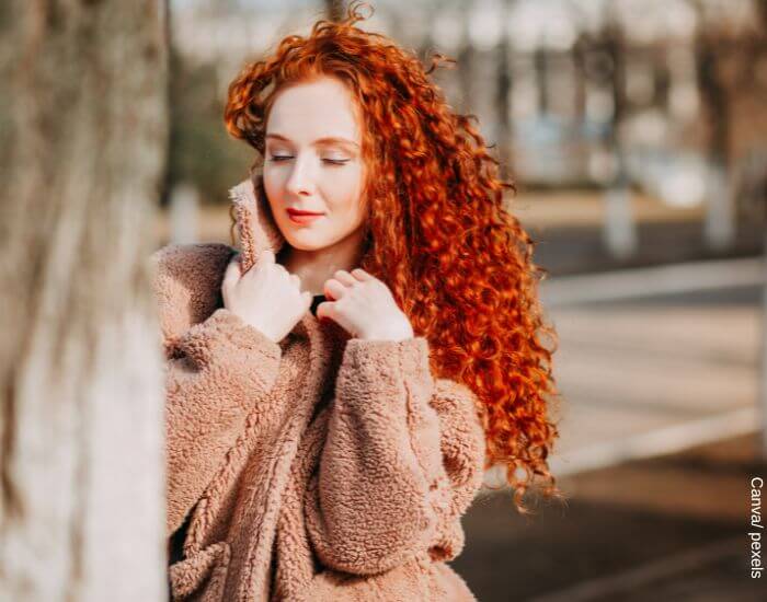 Foto de una mujer peli roja con pelo largo y crespo para representar cómo hacer crecer el cabello