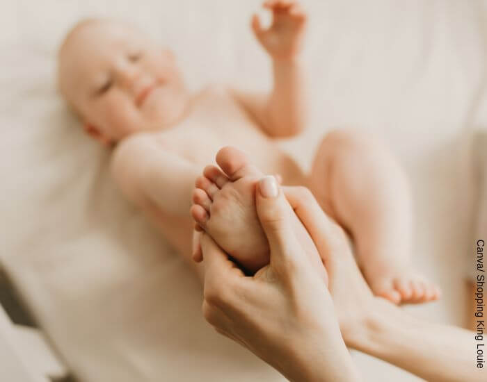 Foto de un bebé siendo masajeado en los pies para representar los masajes para el estreñimiento