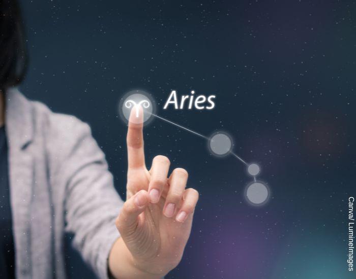 Ilustración de la mano de una mujer dibujand en el aire la constelación del signo Aries