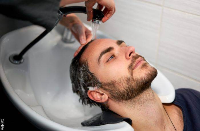Foto de un hombre al que le lavan el cabello