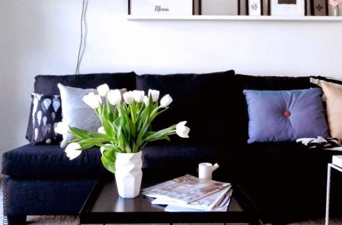Foto de un sofá negro con cojines de colores