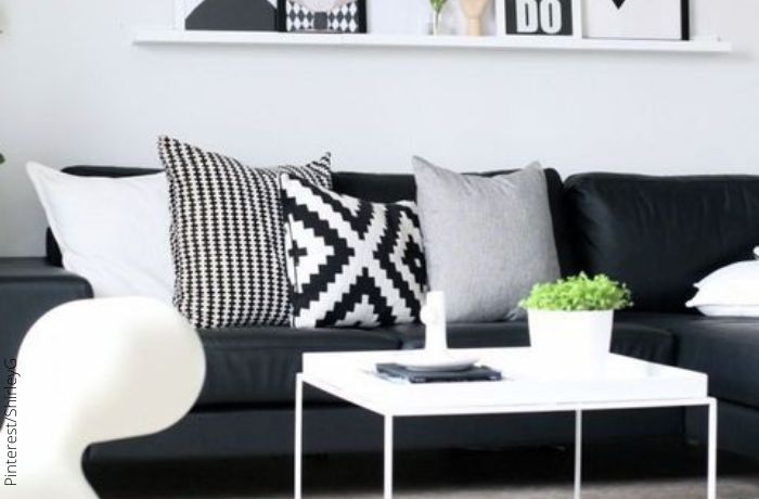 Foto de un sofá negro con cojines a blanco y negro