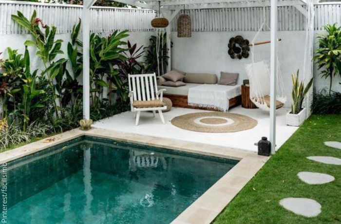 Foto de una piscina rodeada de muebles y vegetación