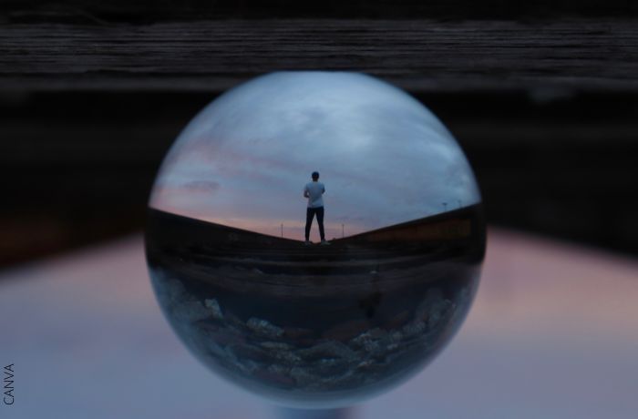 Foto de un hombre en el reflejo de una bola de cristal