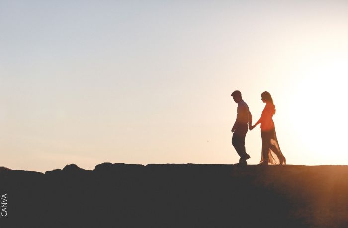 Foto de una pareja caminando por una montaña en el atardecer