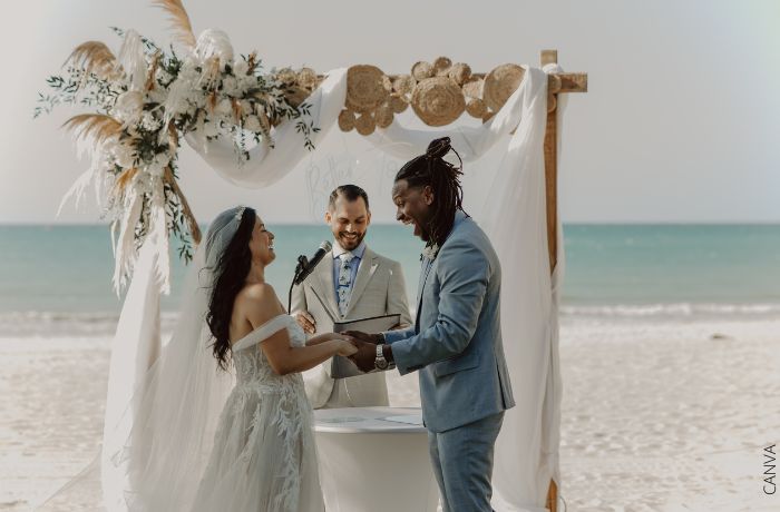 Foto de una pareja riendo en su boda frente al mar