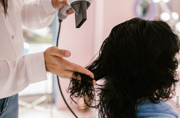 Foto de una mujer secando el cabello de otra con un secador