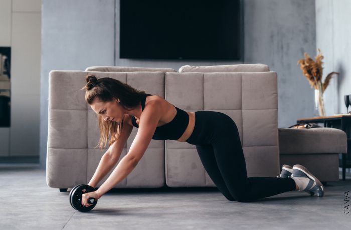 Foto de una mujer haciendo ejercicio con una rueda abdominal
