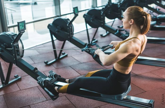 Foto de una mujer haciendo ejercicio de remo en el gimnasio