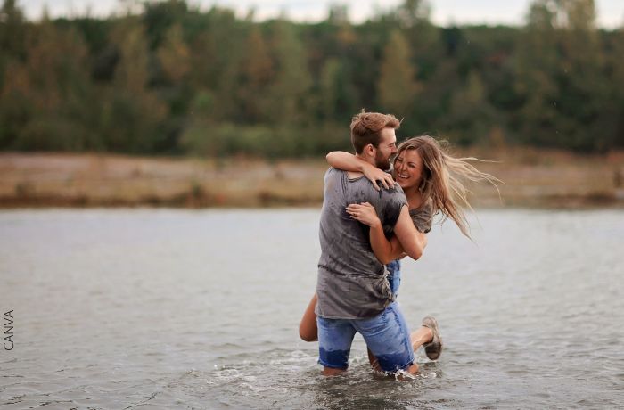Foto de una pareja riendo y abrazada en medio de un río