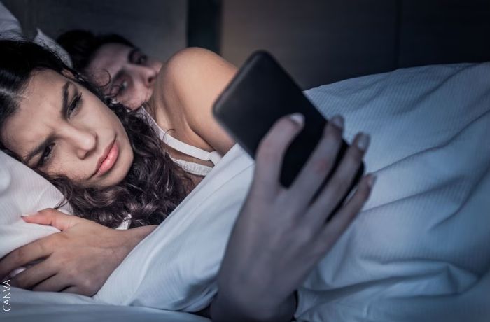 Foto mirando el celular de su pareja mientras lo usa