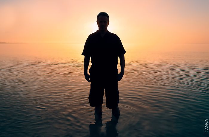 Foto de la silueta de un hombre frente al atardecer en el mar