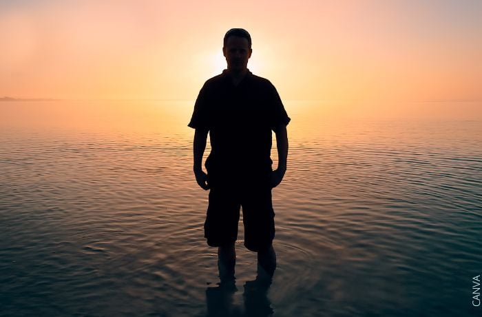 Foto de la silueta de un hombre frente al atardecer en el mar