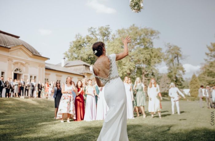 Foto de una mujer lanzando el ramo de novia