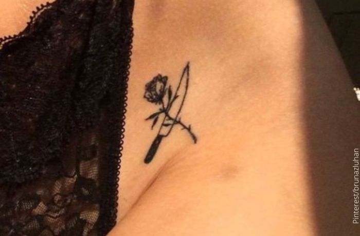 Foto de un tatuaje de una flor y un cuchillo en la ingle