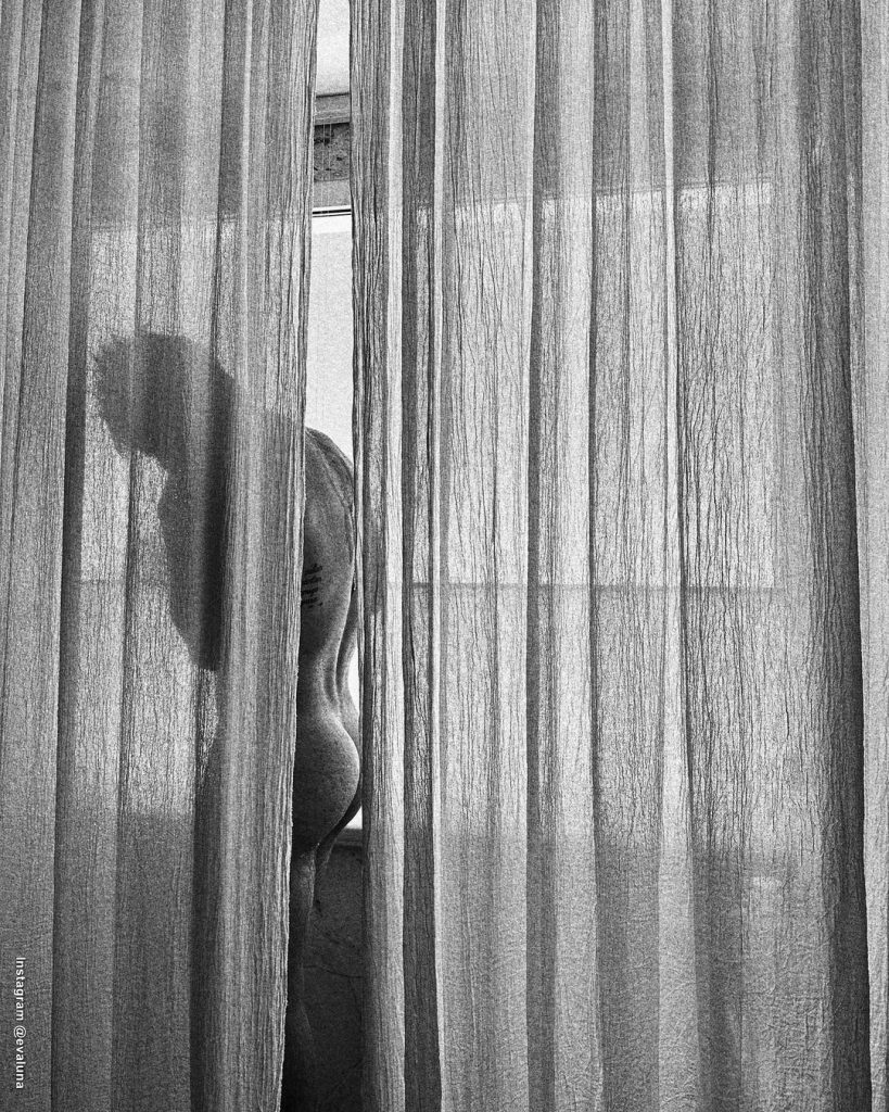 Foto de Camilo detrás de una cortina con su espalda y trasero desnudo