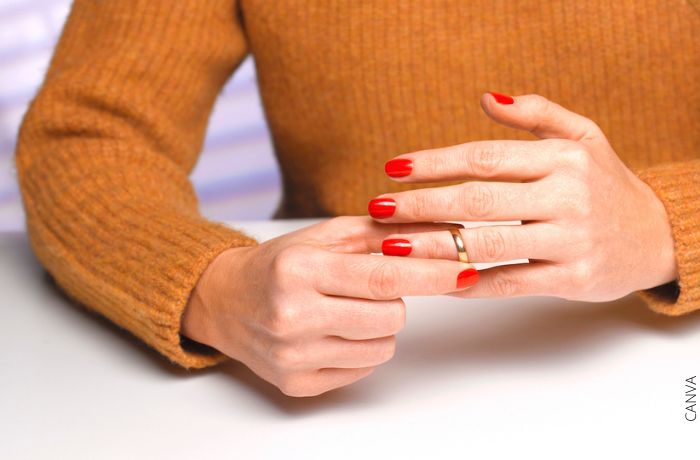 Foto de una mujer quitandose el anillo de matrimonio