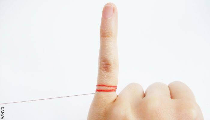 Foto de un dedo meñique con un hilo a su alrededor