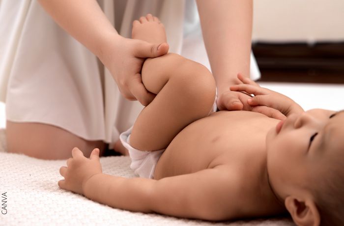 Foto de una persona haciendole masaje a un bebé