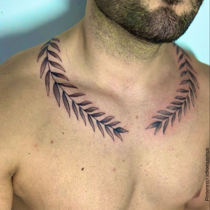 Foto de un hombre con tatuaje de hojas de laurel en los hombros