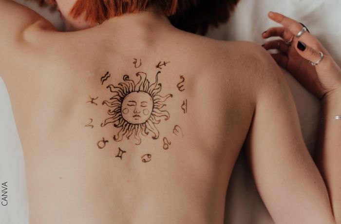 Foto del tatuaje del zodiaco en la espalda de una mujer