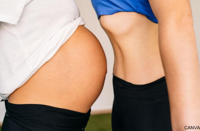 Foto de la barriga de una muejr embarazada frente a otra que no está en embarazo